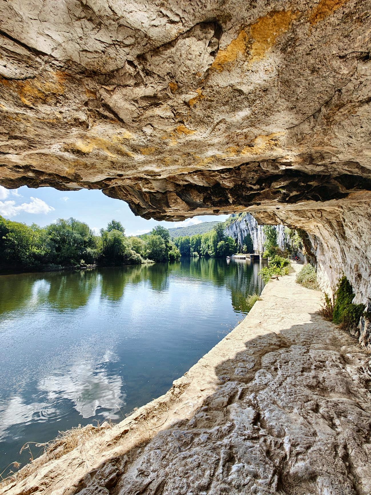 Le chemin de halage sous la falaise, le long de l’eau, dans le Lot