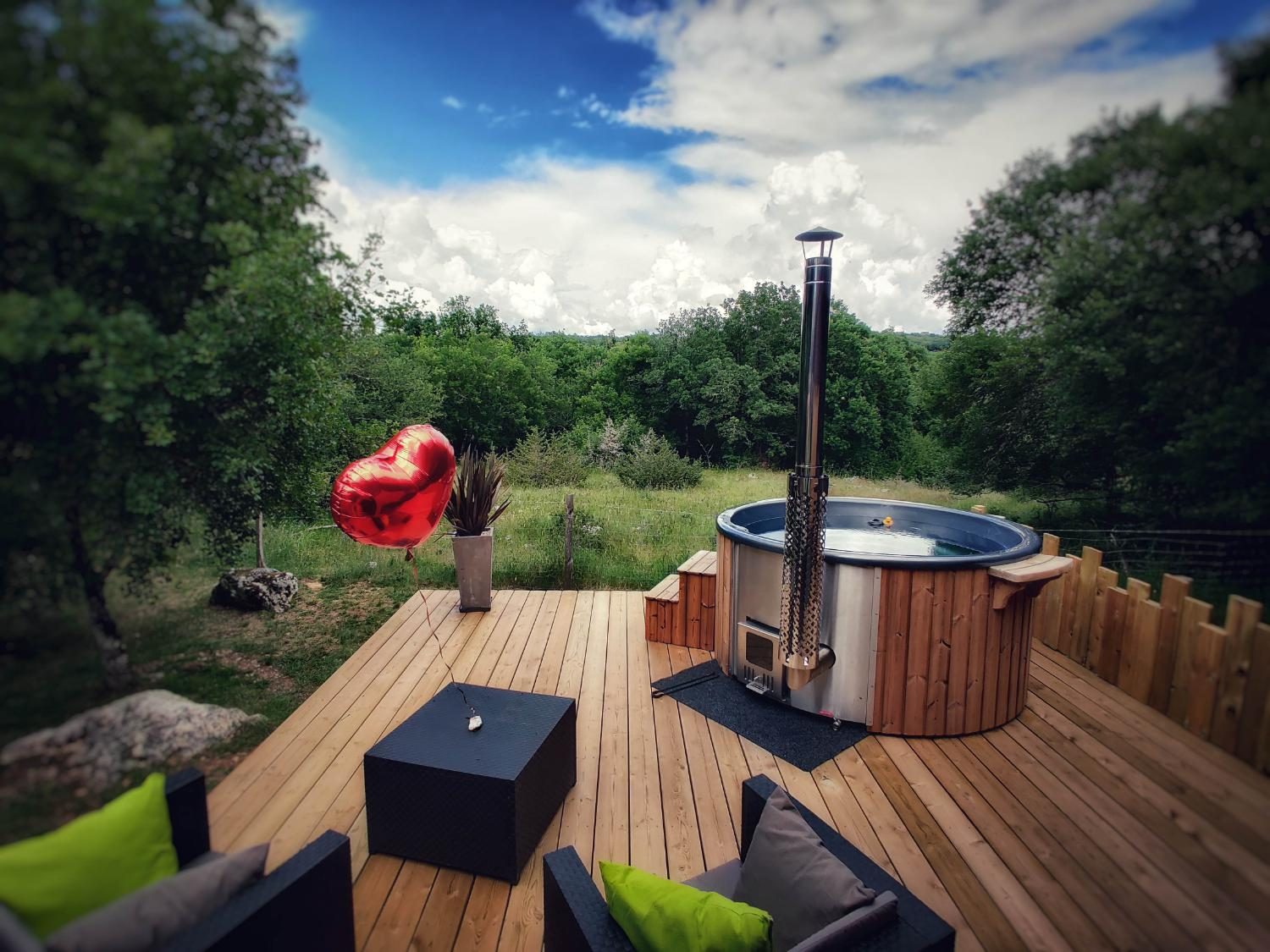 Bain nordique du gîte romantique, terrasse ouverte sur la forêt, à Quissac-en-Quercy dans le Lot