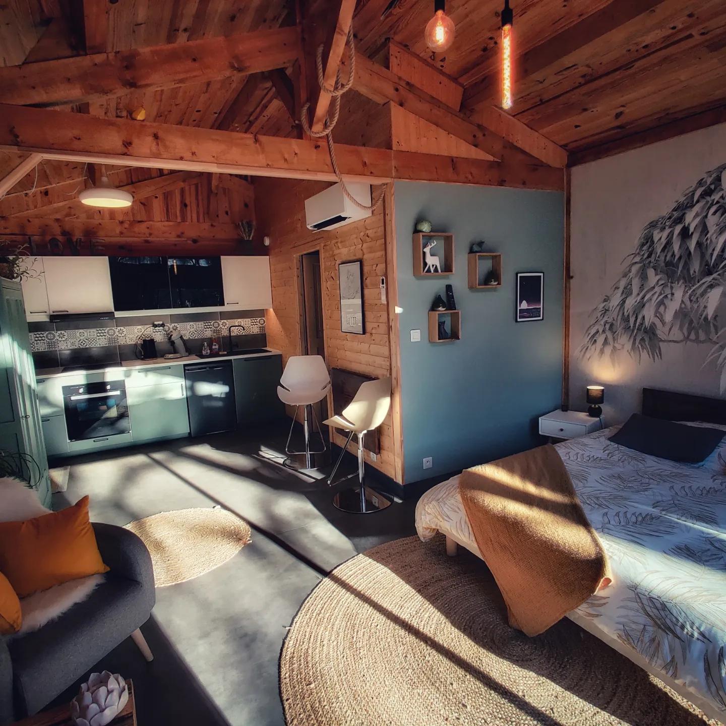 Pièce de vie du gîte au soleil, cuisine et lit dans le chalet